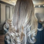 Gray blending: soft blonde highlights woven through graying hair with no harsh regrowth line